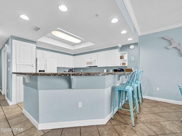 9450 S Thomas Dr Unit 1211, Panama City, FL 32408 - kitchen featuring white appliances, crown molding, dark stone counters, a kitchen bar, and white cabinetry