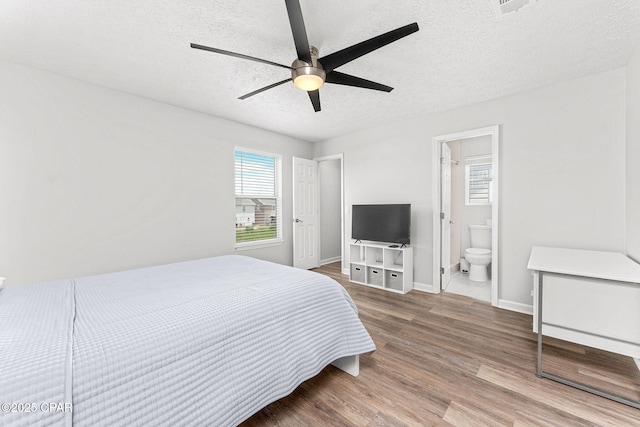 190 White Cap Way, Panama City Beach, FL 32407 - bedroom with a textured ceiling, wood finished floors, baseboards, connected bathroom, and a ceiling fan