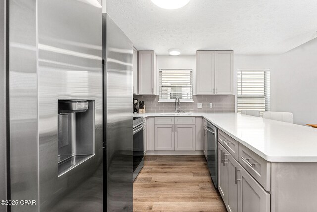 190 White Cap Way, Panama City Beach, FL 32407 - kitchen with appliances with stainless steel finishes, a sink, a peninsula, gray cabinets, and a textured ceiling