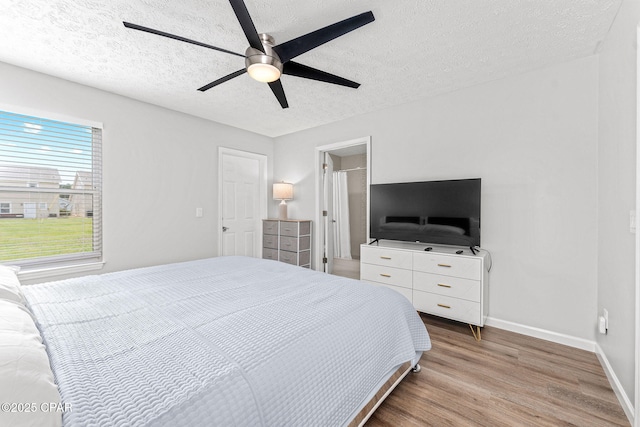190 White Cap Way, Panama City Beach, FL 32407 - bedroom featuring wood finished floors, a textured ceiling, baseboards, and a ceiling fan