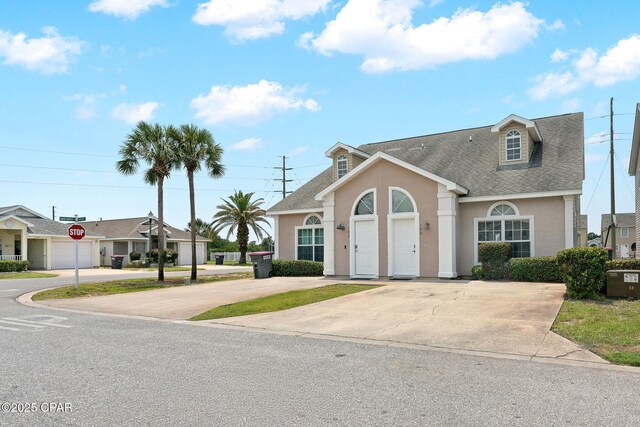 190 White Cap Way, Panama City Beach, FL 32407 - view of front of house featuring stucco siding, a shingled roof, and driveway