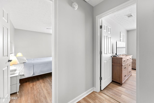 190 White Cap Way, Panama City Beach, FL 32407 - hall featuring a textured ceiling, light wood-style floors, and baseboards