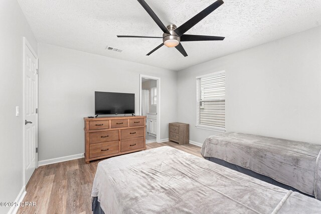 190 White Cap Way, Panama City Beach, FL 32407 - bedroom with light wood-type flooring, baseboards, a textured ceiling, ceiling fan, and ensuite bathroom