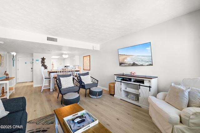 23223 Front Beach Rd Unit C1-502, Panama City Beach, FL 32413 - living room featuring light wood finished floors, a textured ceiling, and baseboards