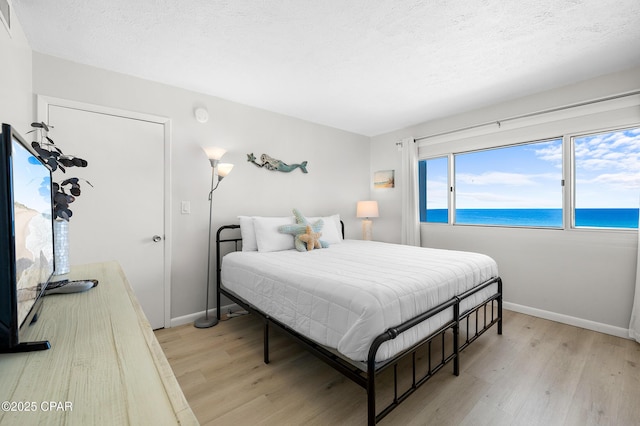 23223 Front Beach Rd Unit C1-502, Panama City Beach, FL 32413 - bedroom with light wood finished floors, baseboards, and a water view