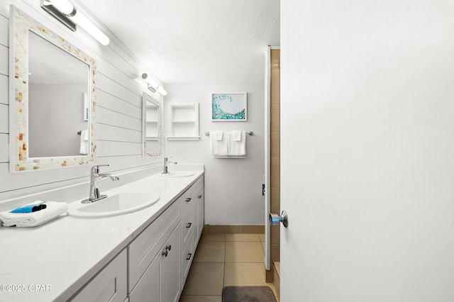 23223 Front Beach Rd Unit C1-502, Panama City Beach, FL 32413 - bathroom with double vanity, tile patterned flooring, a textured ceiling, and baseboards