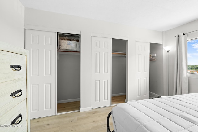 23223 Front Beach Rd Unit C1-502, Panama City Beach, FL 32413 - bedroom with multiple closets, light wood-style floors, and baseboards