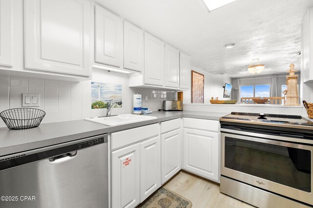 23223 Front Beach Rd Unit C1-502, Panama City Beach, FL 32413 - kitchen featuring stainless steel appliances, a sink, tasteful backsplash, and light wood-style flooring