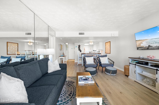 23223 Front Beach Rd Unit C1-502, Panama City Beach, FL 32413 - living room featuring light wood-style flooring, baseboards, and a textured ceiling