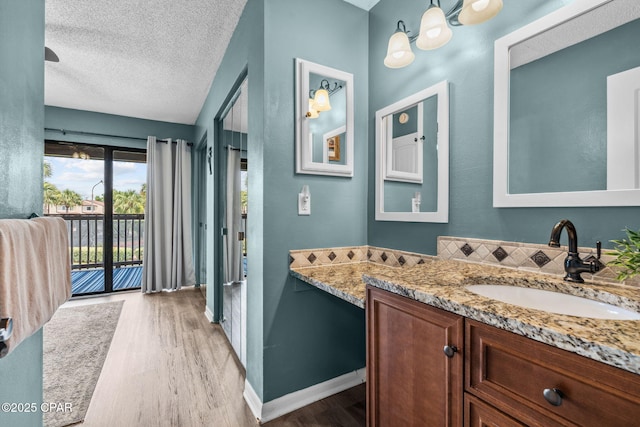 17620 Front Beach Rd Unit P2, Panama City Beach, FL 32413 - bathroom featuring wood finished floors, vanity, a textured ceiling, and baseboards