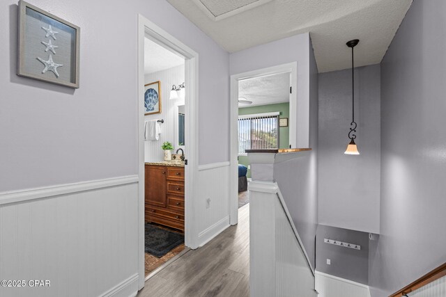 17620 Front Beach Rd Unit P2, Panama City Beach, FL 32413 - corridor featuring wood finished floors, a wainscoted wall, an upstairs landing, and a textured ceiling