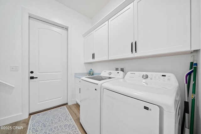 309 Tanaga St, Panama City Beach, FL 32413 - laundry area with washing machine and clothes dryer, light wood finished floors, and cabinet space