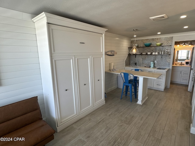 14401 Front Beach Rd Unit 221, Panama City Beach, FL 32413 - kitchen with light wood-type flooring, a breakfast bar area, light countertops, white cabinets, and recessed lighting