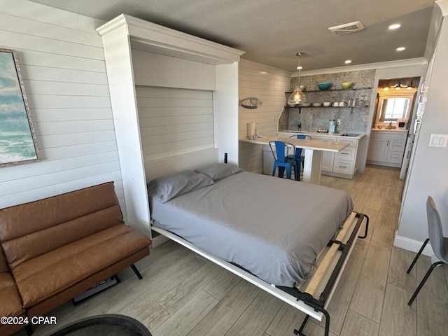 14401 Front Beach Rd Unit 221, Panama City Beach, FL 32413 - bedroom featuring wood walls, light wood-type flooring, and recessed lighting
