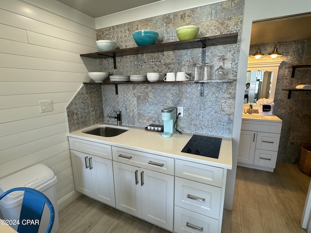 14401 Front Beach Rd Unit 221, Panama City Beach, FL 32413 - bar area featuring a sink, black electric stovetop, light wood finished floors, and tasteful backsplash