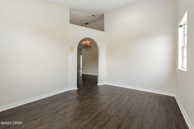 101 Loblolly Ct, Panama City Beach, FL 32413 - spare room featuring dark wood-type flooring, arched walkways, baseboards, and high vaulted ceiling