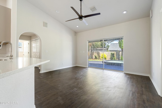 101 Loblolly Ct, Panama City Beach, FL 32413 - unfurnished living room featuring dark wood-type flooring, ceiling fan, a sink, arched walkways, and baseboards