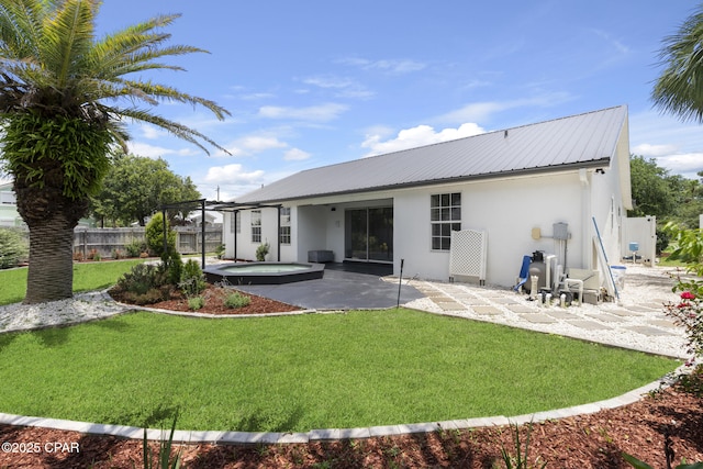 101 Loblolly Ct, Panama City Beach, FL 32413 - back of house featuring stucco siding, an outdoor hot tub, a patio, and metal roof