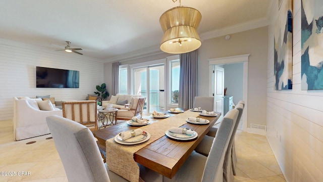 11807 Front Beach Rd Unit 2204, Panama City Beach, FL 32407 - dining area featuring light tile patterned flooring, a ceiling fan, an accent wall, ornamental molding, and wooden walls