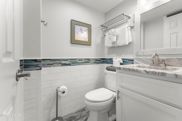 23223 Front Beach Rd Unit 335, Panama City Beach, FL 32413 - half bath featuring tile walls, toilet, vanity, and a wainscoted wall