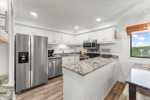 23223 Front Beach Rd Unit 335, Panama City Beach, FL 32413 - kitchen featuring stainless steel appliances, a sink, a peninsula, white cabinets, and crown molding