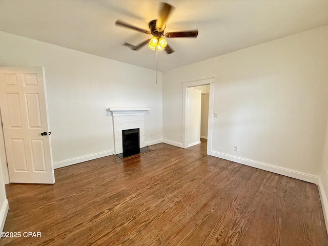 2969 Russ St, Marianna, FL 32446 - unfurnished living room with ceiling fan, dark wood-style flooring, a fireplace, and baseboards