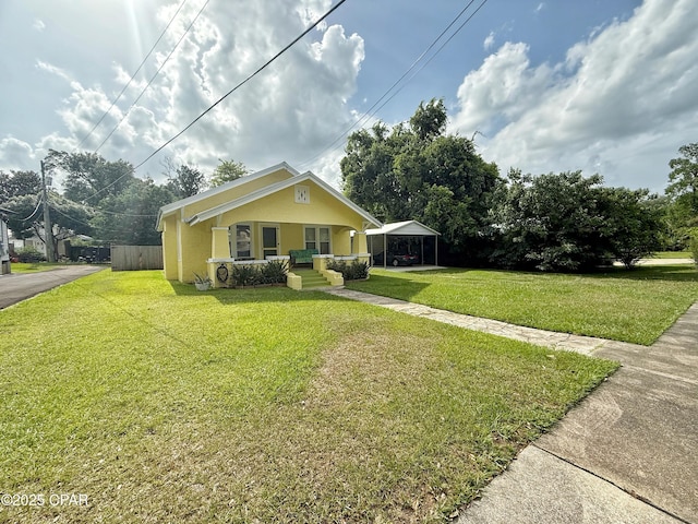 2969 Russ St, Marianna, FL 32446 - view of front of property featuring a front lawn, a carport, covered porch, and stucco siding