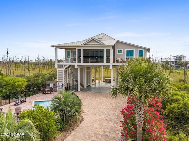 766 Secluded Dunes Dr, Port St Joe, FL 32456 - back of property featuring stairs, decorative driveway, a carport, a metal roof, and a patio area