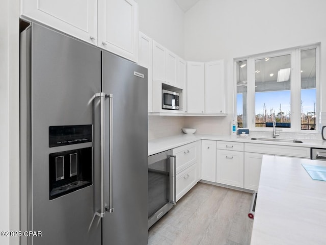 766 Secluded Dunes Dr, Port St Joe, FL 32456 - kitchen featuring appliances with stainless steel finishes, beverage cooler, white cabinets, and light countertops