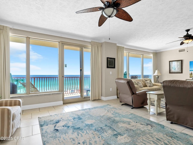 7115 Thomas Dr Unit 602, Panama City Beach, FL 32408 - tiled living area with ceiling fan, healthy amount of natural light, a textured ceiling, and a water view