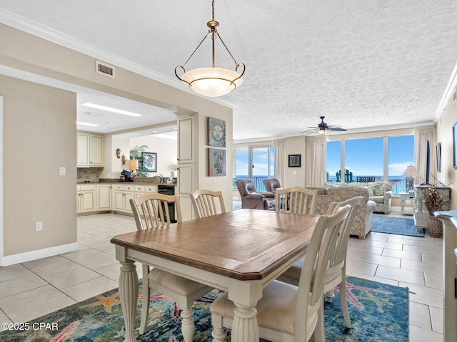 7115 Thomas Dr Unit 602, Panama City Beach, FL 32408 - dining space with light tile patterned flooring, ceiling fan, a textured ceiling, and crown molding