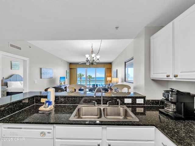15817 Front Beach Rd Unit 1-204, Panama City Beach, FL 32413 - kitchen with dishwasher, open floor plan, a chandelier, white cabinets, and dark stone countertops