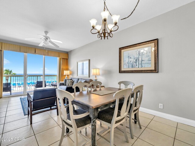 15817 Front Beach Rd Unit 1-204, Panama City Beach, FL 32413 - dining space with light tile patterned floors, a ceiling fan, a chandelier, and a water view