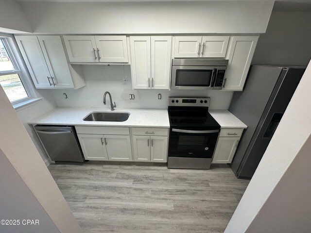 6336 Omoko St, Panama City, FL 32404 - kitchen featuring stainless steel appliances, light wood-style floors, and light stone countertops
