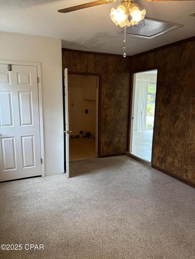 5360 Constitution Rd, Crestview, FL 32539 - unfurnished bedroom with carpet flooring, wood walls, a textured ceiling, and a ceiling fan