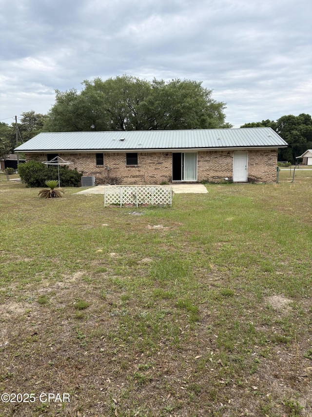 5360 Constitution Rd, Crestview, FL 32539 - back of house featuring a metal roof, a yard, and brick siding