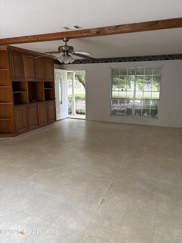 5360 Constitution Rd, Crestview, FL 32539 - unfurnished living room featuring beam ceiling, a textured ceiling, plenty of natural light, a ceiling fan, and light flooring