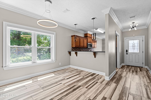 2932 Palmetto Ridge Way, Lynn Haven, FL 32444 - kitchen featuring brown cabinetry, dark countertops, stainless steel microwave, a textured ceiling, and a breakfast bar