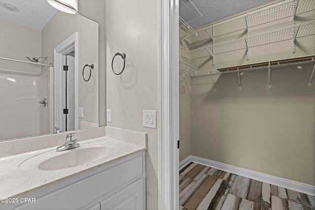 2932 Palmetto Ridge Way, Lynn Haven, FL 32444 - full bathroom featuring vanity, wood finished floors, a spacious closet, and a textured ceiling