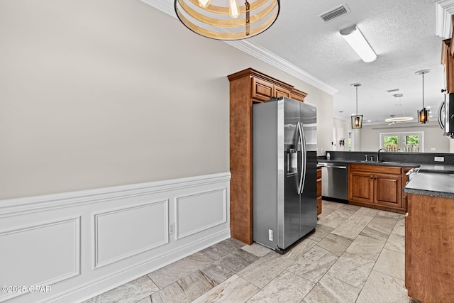 2932 Palmetto Ridge Way, Lynn Haven, FL 32444 - kitchen with stainless steel appliances, dark countertops, crown molding, brown cabinets, and pendant lighting
