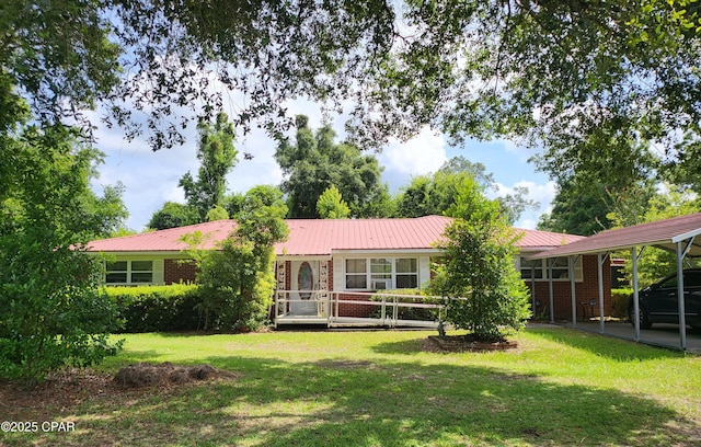 4010 Old Cottondale Rd, Marianna, FL 32448 - back of house with brick siding, a lawn, a carport, and a metal roof