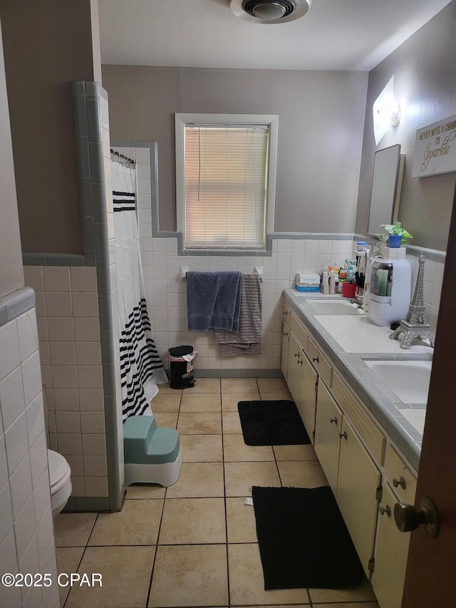 4010 Old Cottondale Rd, Marianna, FL 32448 - bathroom featuring tile walls, tile patterned floors, double vanity, a wainscoted wall, and curtained shower