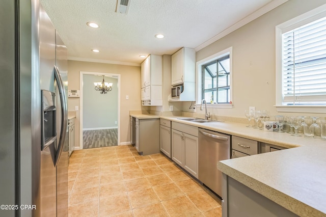 3127 4th St, Marianna, FL 32446 - kitchen featuring appliances with stainless steel finishes, crown molding, a chandelier, a textured ceiling, and light countertops