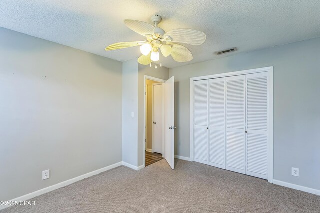 3127 4th St, Marianna, FL 32446 - unfurnished bedroom with carpet floors, a closet, a textured ceiling, and a ceiling fan