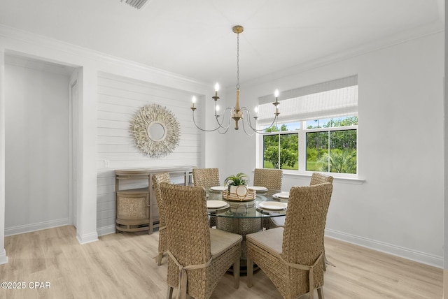 8648 Conch Shell Ct, Panama City Beach, FL 32413 - dining space featuring light wood-type flooring, ornamental molding, and a chandelier