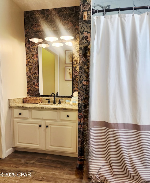 184 White Cap Way, Panama City Beach, FL 32407 - bathroom featuring wallpapered walls, vanity, wood finished floors, and a shower with curtain