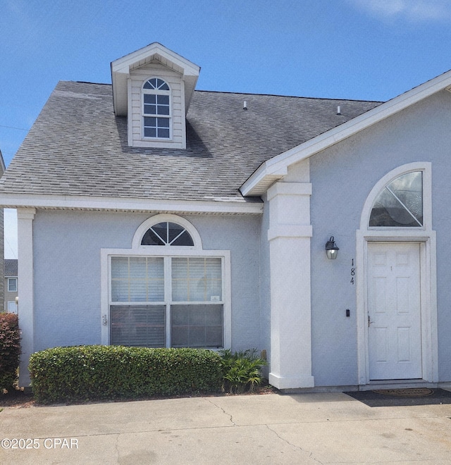 184 White Cap Way, Panama City Beach, FL 32407 - view of exterior entry featuring a shingled roof and stucco siding