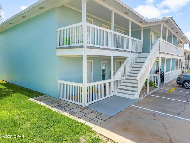 17642 Front Beach Rd Unit B1, Panama City Beach, FL 32413 - view of property featuring stairway and uncovered parking