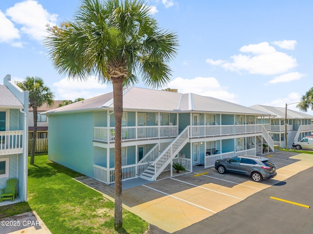 17642 Front Beach Rd Unit B1, Panama City Beach, FL 32413 - view of property featuring stairway, uncovered parking, and a residential view