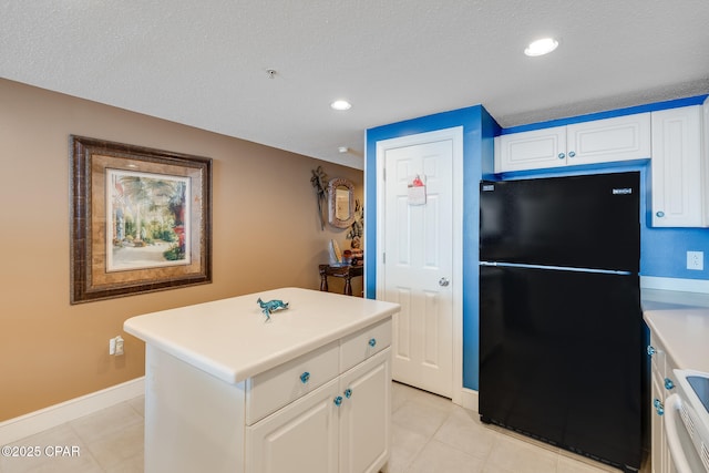 10811 Front Beach Rd Unit 2304, Panama City Beach, FL 32407 - kitchen featuring freestanding refrigerator, light tile patterned flooring, white cabinets, light countertops, and a kitchen island